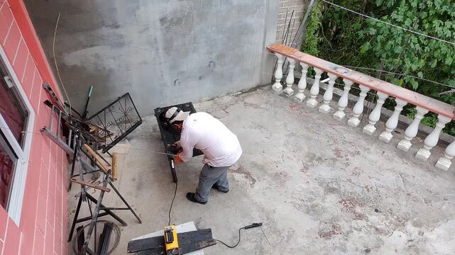 Welder Tapping Slag Off Welded Metal Sheet with Chipping Hammer