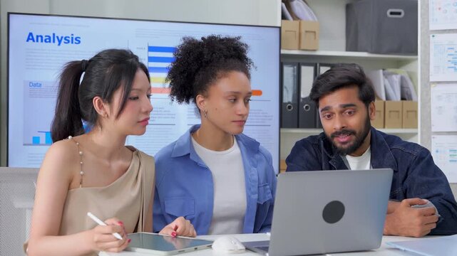 A diverse team of colleagues collaborates in a modern office, reviewing data analytics and growth charts on a tablet during a business meeting, showcasing teamwork, diversity, and workplace technology