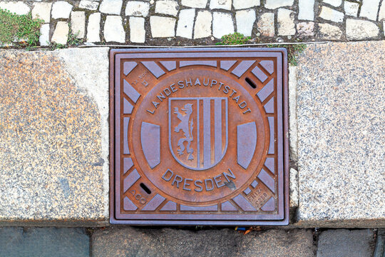 A square rusty manhole cover in Dresden, Germany