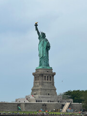 Statue of Liberty on Liberty Island under an overcast sky © M