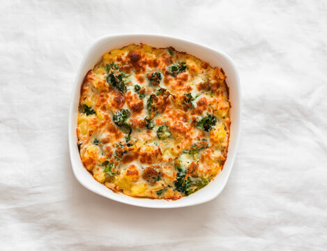 Baked frittata with broccoli, potatoes and chicken in a baking dish - a delicious breakfast, snack, tapas on a light background, top view