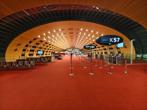 Paris, France-Dec.3rd 2025: Wide-angle of the gate area at Charles de Gaulle Airport (CDG), Terminal 2E, Gate K57, featuring red carpet and iconic wooden arched ceiling.