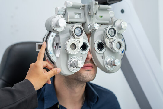 Individual receiving a comprehensive eye test using advanced phoropter in a contemporary optical retail environment