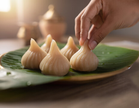 Hand Placing Modak on Banana Leaf