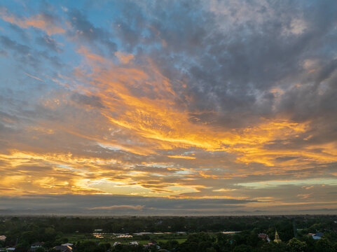 Golden sunrise over Mae rim district, Chiang Mai, Thailand spreads warm light across foggy suburbs.