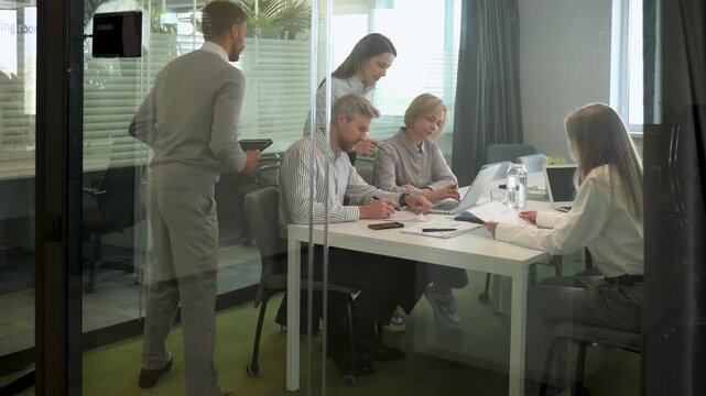 Creative business people, planning and meeting and brainstorming, ideas or strategy at office, view from glass wall.