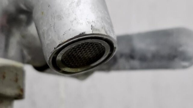 Close up water faucet nozzle spraying, representing plumbing, water flow, and household fixture footage.