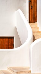 Fototapeta premium Sunlit Mediterranean white architecture with soft curved walls and wooden doors. Clean surfaces and warm stone accents create a serene, elegant travel atmosphere.