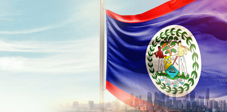 Belize national flag wavering in beautiful clouds with building skyline. Modern Building skyline with national flag. Belize national flag for independence day.