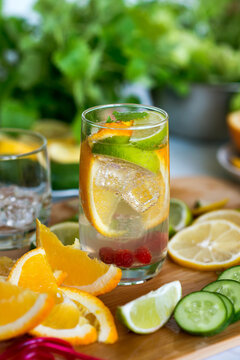 Citrus orange cold drink with mint on an old wooden background with mint and slices of lime and lemon.
