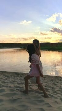 Mother and daughter walk together along a lakeshore at sunset, peaceful family bonding, summer evening, maternal love and scenic outdoor lifestyle.