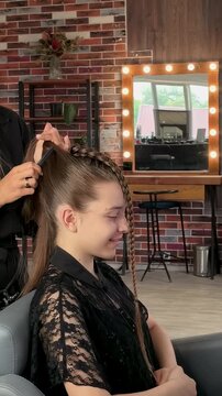 Teenage girl gets a sleek braided ponytail hairstyle in a salon, professional hairstyling, youthful fashion and elegant beauty transformation.