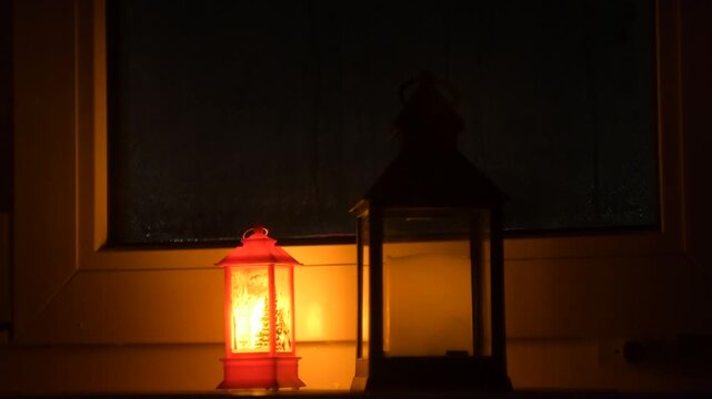 Cozy glowing decorative lanterns on a windowsill during a dark winter evening