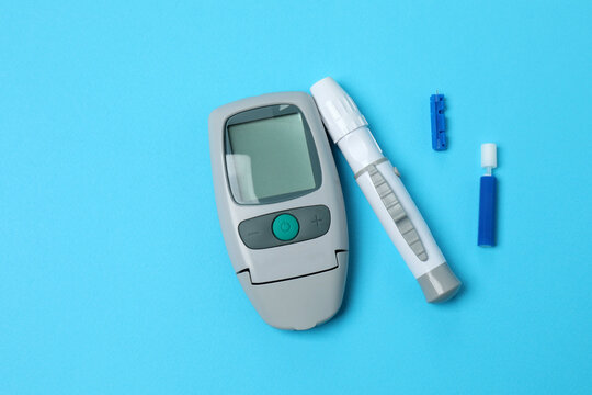 Blood glucose meter with lancets, top view. Medical device and diabetes concept.
