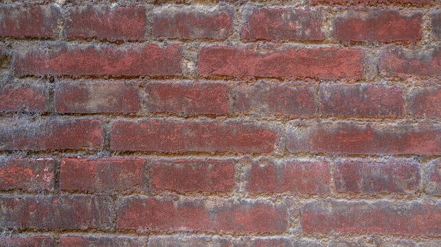 Pared de ladrillos rojos desgastados con textura r&uacute;stica