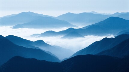 Fototapeta premium Misty blue mountain range at dawn with white clouds