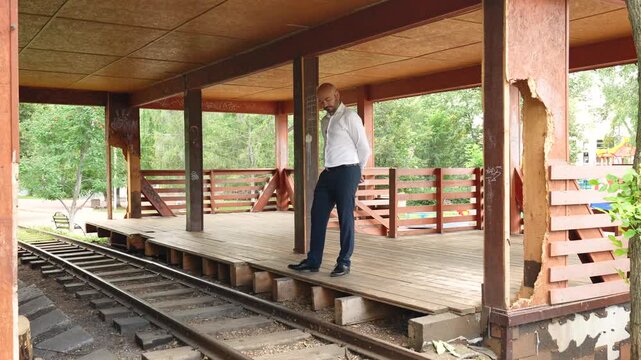 Man waiting for a train at an old railway station platform