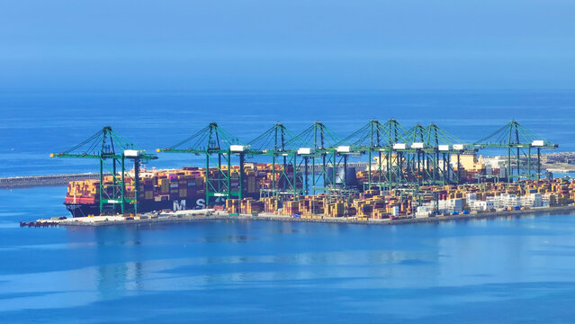 Sines, Portugal - 20 June 2026: Aerial view of the Port of Sines container terminal with large cargo ships, colorful shipping containers, and towering gantry cranes along the coast.