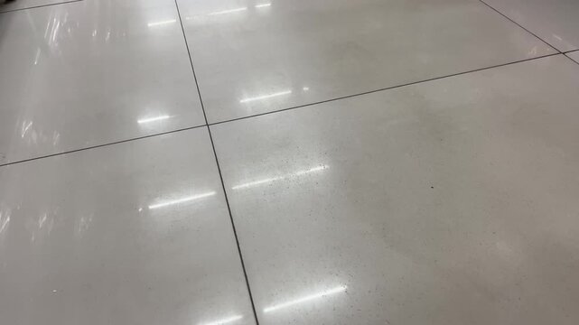 Shiny White Ceramic Tiled Floor with Bright Indoor Light Reflection