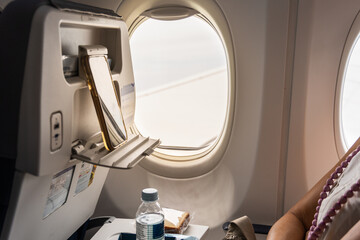 Passenger watching movie on smart phone placed on back of front seat during long haul flight © ThamKC