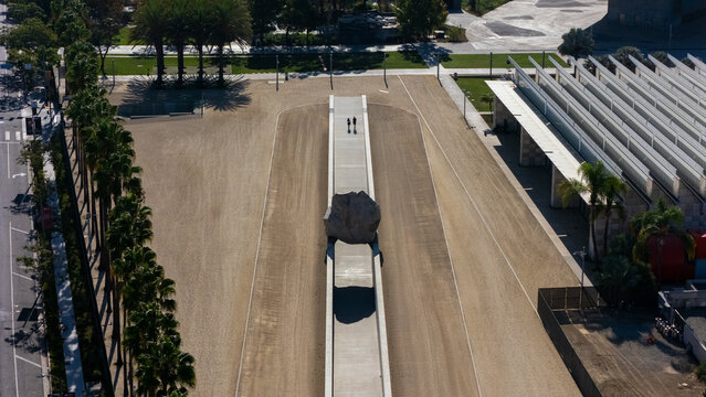 Los Angeles, United States - 26 August 2026: Aerial view of the Academy Museum of Motion Pictures and the Levitated Mass boulder, surrounded by palm trees and modern architecture.
