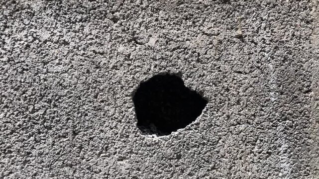 Hole in Concrete Block: A close-up shot reveals a rough concrete block with a dark, irregular hole, highlighting texture and imperfection.