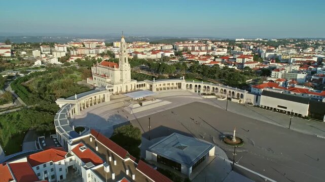 Aerial view of the Sanctuary of Fatima with its basilica and expansive prayer square surrounded by urban buildings in Fatima, Santarem District, Portugal.