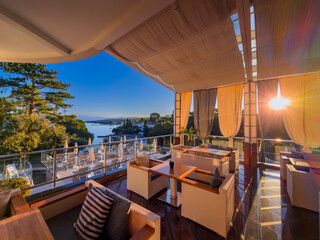 Obraz premium Covered luxury terrace lounge with armchairs and sea view at a resort in Croatia.