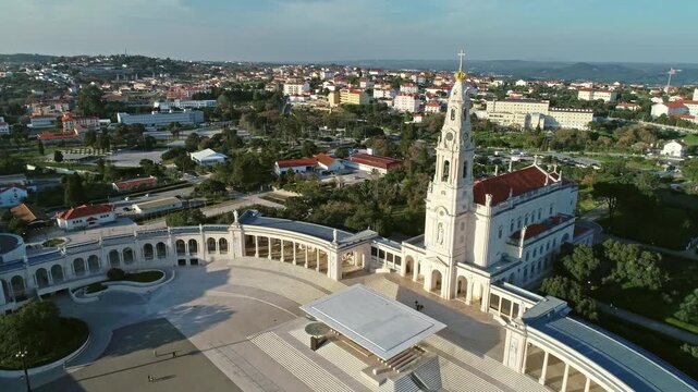 Aerial view of the Sanctuary of Fatima with its iconic basilica, colonnades, and expansive plaza surrounded by the town of Fatima, Santarem District, Portugal.
