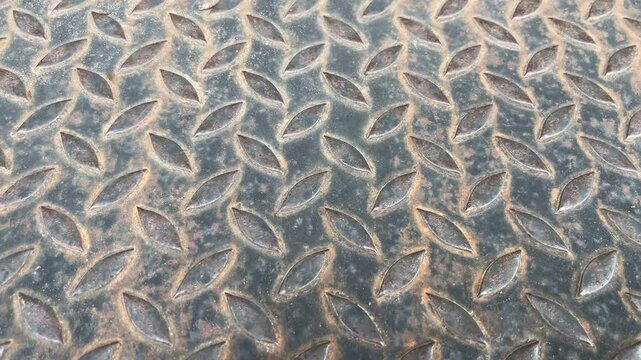 Metal Plate Texture: Close-up of a textured metal plate with a diamond pattern, showcasing its industrial feel and resilience.