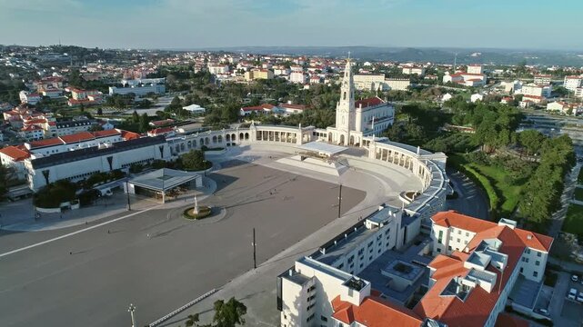 Aerial view of the Sanctuary of Our Lady of Fatima with its expansive plaza and basilica surrounded by urban buildings in Fatima, Santarem District, Portugal.