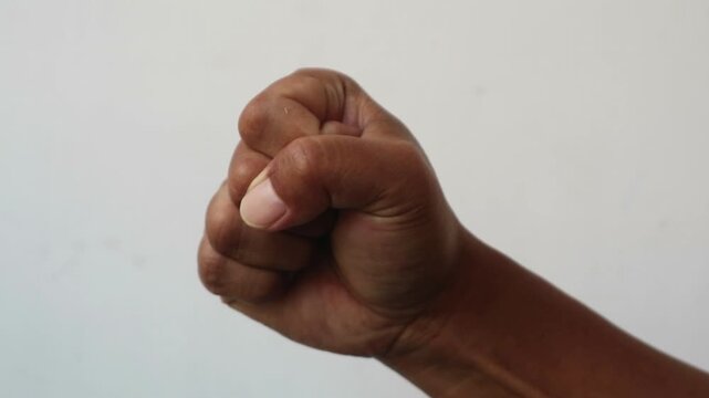 A close up of a human hand clenched in a tight fist.