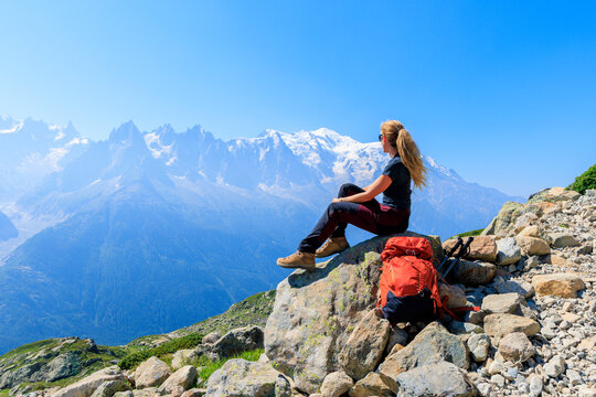 Female hiker sitting on rock enjoying Mont Blanc mountain view in Chamonix France
