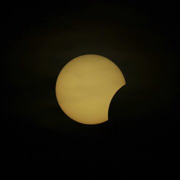 Eclipse of Sun, August 12, 2026. The sun is a gold dish in the sky gradually covered by the moon.