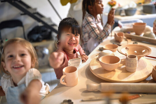smiling children with brush and handmade pots at art workshop class.  Creative, hobby ,activities concept
