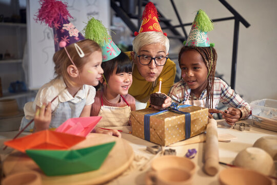 Children celebrate birthday together in group on clay modeling school