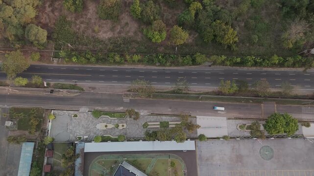 Aerial View of Serene Roadside Landscape Surrounded by Lush Greenery and Urban Elements