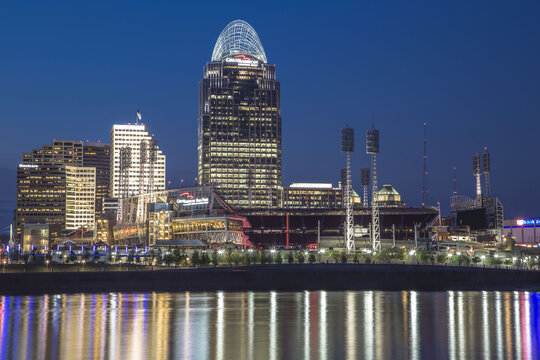 Cincinnati, Ohio, United States - 05 May 2015: View of the illuminated Cincinnati skyline at night, featuring the Great American Tower and Great American Ball Park reflecting in the Ohio River.
