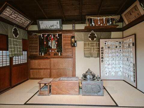 Nikko, Japan - 29 August 2026: View of a traditional Japanese interior featuring tatami mats, a wooden hearth, and historic artifacts displayed on the walls.