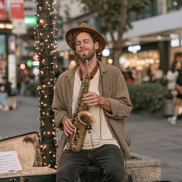 Young street musician playing the saxophone with passion outdoors on a festive evening city street