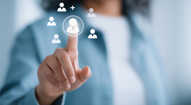 Woman pressing a virtual user icon interface to select human resources candidates on a clear digital display.
