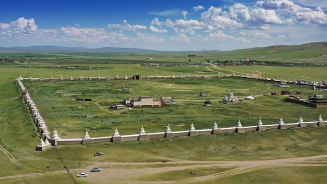 Aerial view of the historic Erdene Zuu Monastery surrounded by white stupas and stone walls in the vast grasslands of Kharkhorin, Ovorkhangai, Mongolia.