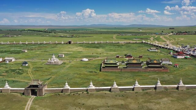 Aerial view of the historic Erdene Zuu Monastery complex with its iconic stupas and temple buildings surrounded by green grasslands in Kharkhorin, Ovorkhangai, Mongolia.
