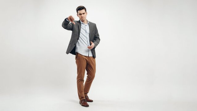 Serious Businessman Showing Thumbs Down Gesture on White Background