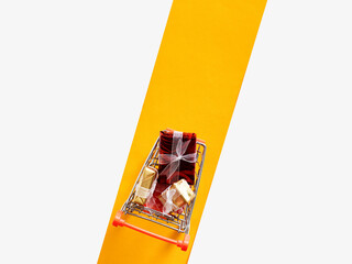 Miniature shopping cart carrying colorful wrapped gifts © Cagkan