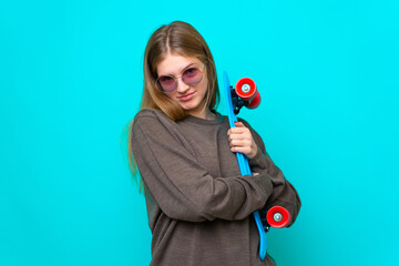 Teenager skater girl isolated on blue background © luismolinero
