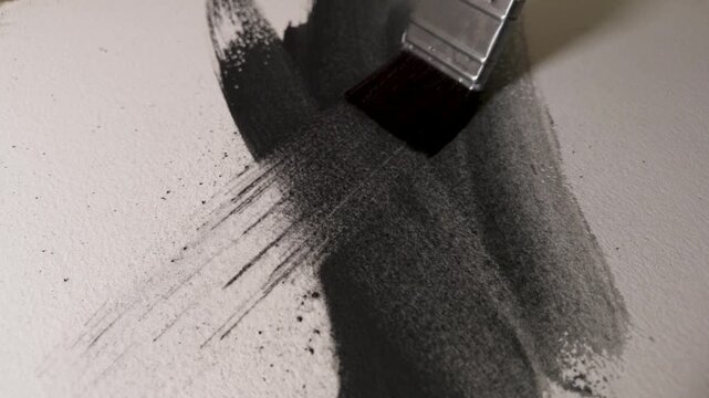 Watercolor graphite brushstrokes spreading across textured paper, layered marks and changing gray tones in slow motion