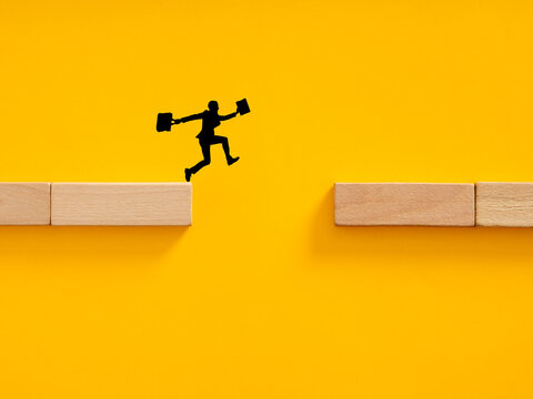 Business person overcoming challenge by jumping gap