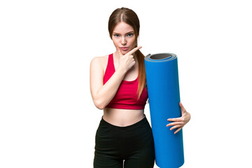 Young sport woman going to yoga classes while holding a mat over isolated chroma key background thinking © luismolinero