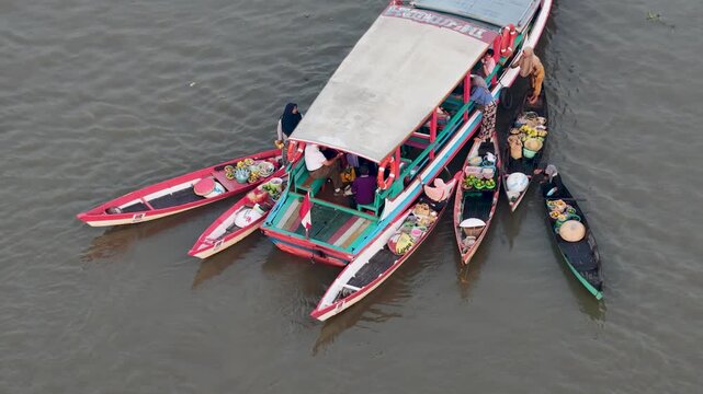 Traders exchange local produce from small wooden boats at Lok Baintan Floating Market in Borneo